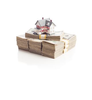 Small House on Stacks of Hundred Dollar Bills Isolated on a White Background.