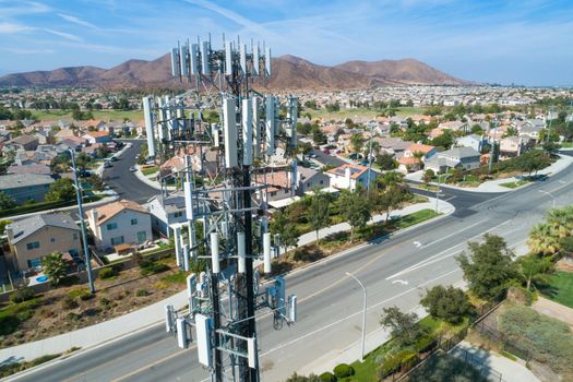 Close-up Aerial of Cellular Wireless Mobile Data Tower with Neighborhood Surrounding.