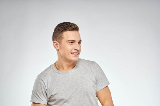 Handsome man in gray t-shirt cropped view of emotion Studio Model. High quality photo