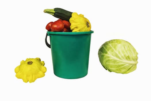 On a white background fresh vegetables lie - cabbage, zucchini, squash and tomatoes
