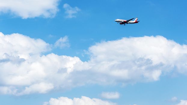 Passenger aircraft sets to land among cumulus clouds