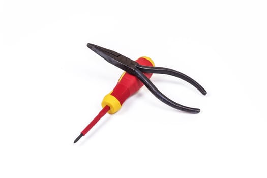 On a light background lie a screwdriver and pliers