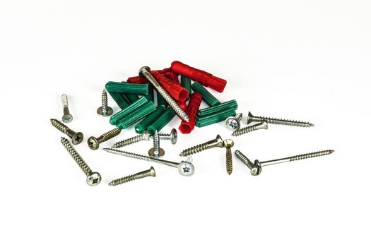 Self-tapping screws and plastic dowels on a light background