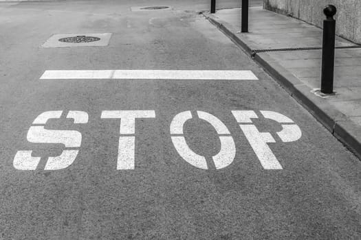 On the asphalt roadway marked the road marking "STOP"