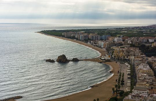 Embankment and sand beach of Blanes in cloudy weather (Spain)