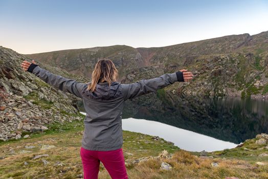 Woman in the Vall de Riu lake from the Estanyo peak in Andorra in summer 2020.