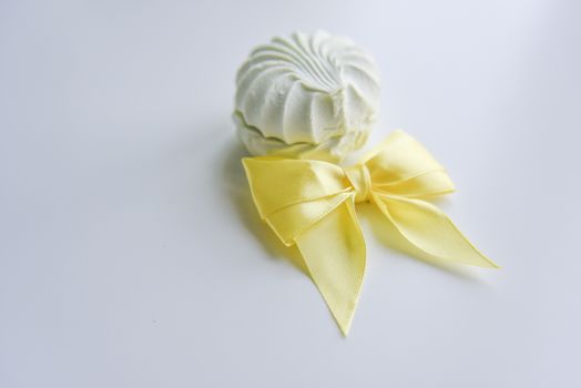 selective focus at the light green marshmallow on the light background with the yellow ribbon