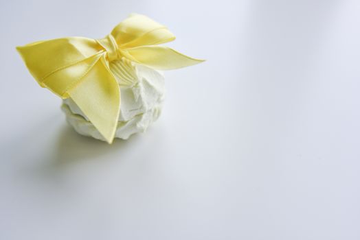 selective focus at the light green marshmallow on the light background with the yellow ribbon