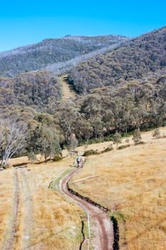 Mountain bikers descend down Thredbo on a cool autumn day in the Snowy Mountains, New South Wales, Australia