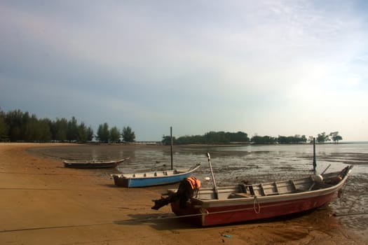 three wooden fishing boats docking on the beach at Port Dickson Malaysia