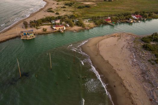 beautiful landscapes of the valleys near Ravenna ,Fiumi Uniti, where the river flows into the sea with the typical fishermen's huts at sunset