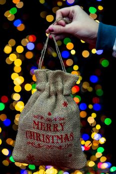 Woman's hands hold christmas decoration. Christmas and New Year holidays background, winter season with Christmas ornaments and blurred lights