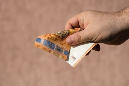 Man hands giving money like a bribe or tips. Holding EURO banknotes on a blurred background, EU currency