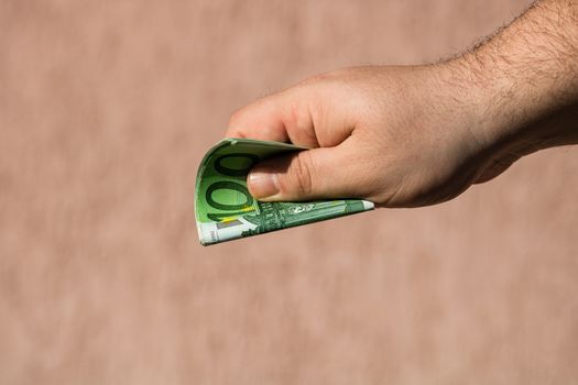 Man hands giving money like a bribe or tips. Holding EURO banknotes on a blurred background, EU currency