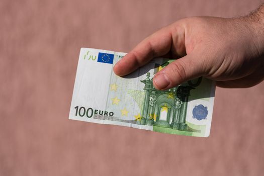 Man hands giving money like a bribe or tips. Holding EURO banknotes on a blurred background, EU currency