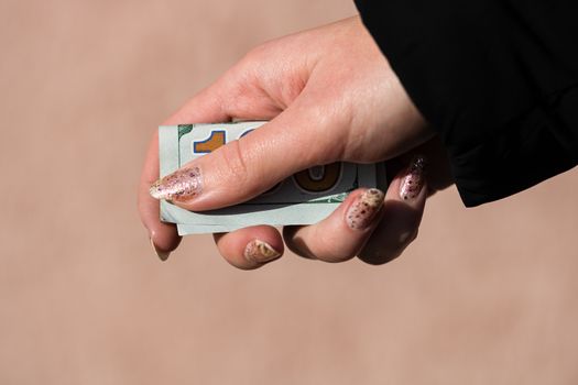 Hands giving money like a bribe or tips. Holding US dollars banknotes on a blurred background, US currency