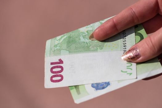 woman hands giving money like a bribe or tips. Holding EURO banknotes on a blurred background, EU currency