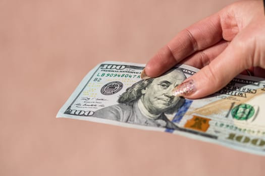 Hands giving money like a bribe or tips. Holding US dollars banknotes on a blurred background, US currency