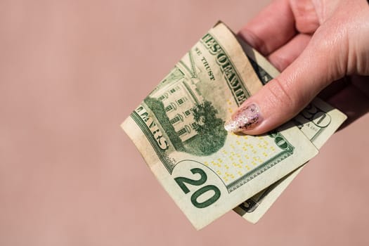 Hands giving money like a bribe or tips. Holding US dollars banknotes on a blurred background, US currency