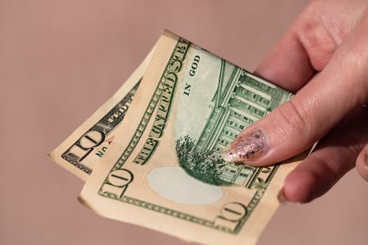 Hands giving money like a bribe or tips. Holding US dollars banknotes on a blurred background, US currency