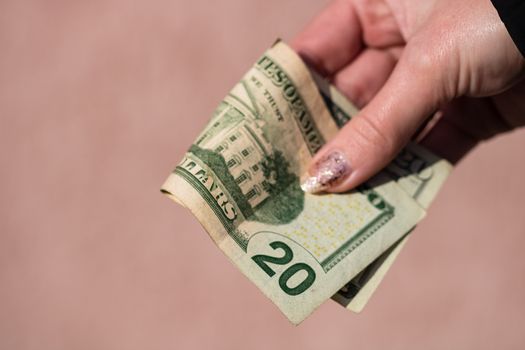 Hand holding or giving dollars money. Holding US dollars banknote on a blurred background, US currency