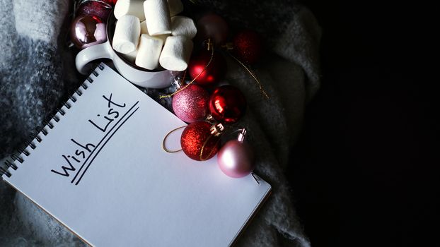Christmas background with wish list, coffee mug with marshmallow and Christmas balls