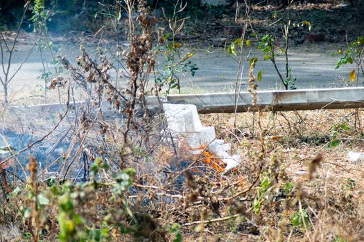 shot of crops thrash garbage being burnt on the side of a road and causing pollution with smoke and dust in the air of delhi jaipur and more reducing the air quality. Shows the daily activities that are causing delhi NCR to have it's worst crisis ever in terms of air quality in winters