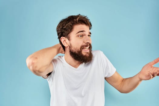 Emotional man with a beard in a white t-shirt blue background fun lifestyle. High quality photo