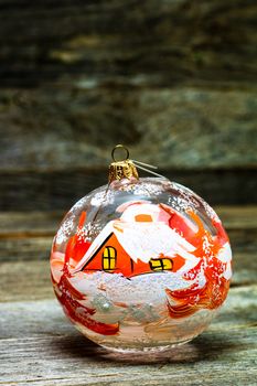 Close up of decorated glass Christmas ball bauble on wooden background,