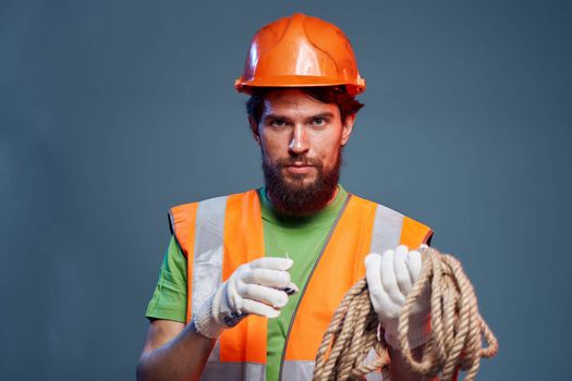 A man in a working uniform with a rope in his hands emotions construction lifestyle. High quality photo
