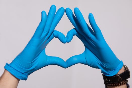Hands with blue gloves making a heart shape stock photo