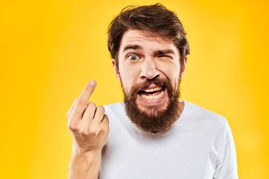 emotional bearded man gesturing with hands aggression discontent close-up yellow background. High quality photo