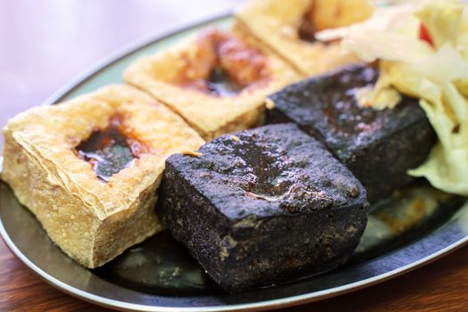 Deep fried stinky tofu, fermented bean curd with pickled cabbage vegetable, famous and delicious street food in Taiwan, lifestyle.