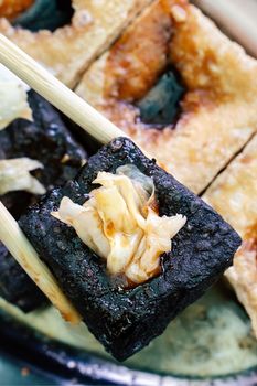 Deep fried stinky tofu, fermented bean curd with pickled cabbage vegetable, famous and delicious street food in Taiwan, lifestyle.