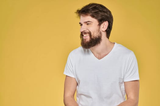 Bearded man on emotions white t-shirt fun lifestyle yellow background. High quality photo