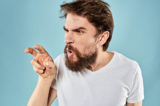 Man with disgruntled facial expression gesturing with hands studio lifestyle blue background. High quality photo