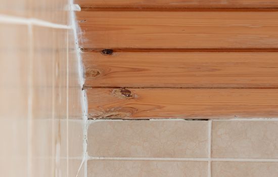 Old brown tiles in a bathroom in need of some maintenance