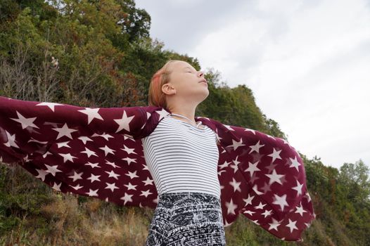 teenage girl with a handkerchief fluttering in the wind in her hands,