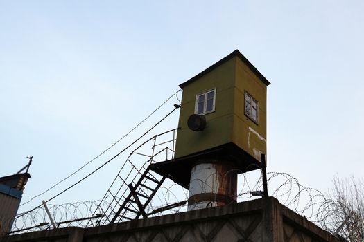 prison watchtower behind barbed wire in the zone close up