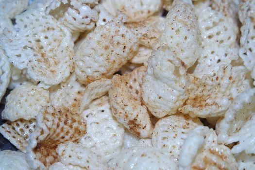 Closeup view of freshly fried chips as fast food for tea break. Potato chips with spices sprinkled on it. Fast food background for advertisements.