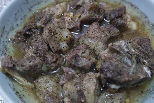 Top view of siri paaye or paya dish garnished with diced ginger, long coriander and black pepper. This dish is popular in Pakistan and Bangladesh