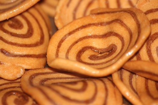 Closeup view with selective focus of a large number of round cookies with coconut filling lines.