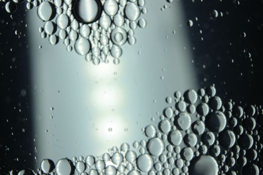 abstract macro background of oil circles floating over water surface . Macro closeup view of bubbles on water . oil bubbles in the water macro photographic background