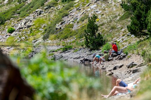 Coma Pedrosa, Andorra : 02 August 2020 : 
Group of tourists resting at Lago de les Truites in Andorra Pyrenees in summer 2020.