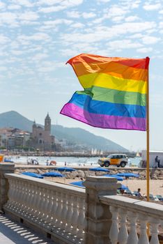 Sitges, Catalonia, Spain: July 28, 2020: Flag gay whit People on the Paseo Maritimo in the city of Sitges in the summer of 2020.