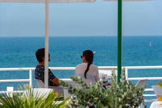 Sitges, Catalonia, Spain: July 28, 2020: Gay couple walking on the beach in Sitges in summer 2020.