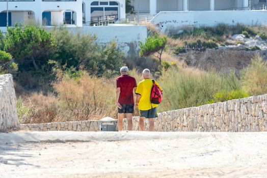 Sitges, Catalonia, Spain: July 28, 2020: Gay couple walking on the beach in Sitges in summer 2020.
