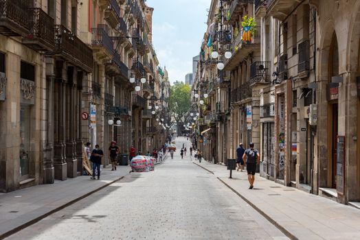 Barcelona, Spain - July 28 2020:  People walking through empty streets after COVID 19 in Barcelona, Spain.