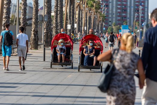 Barcelona, Spain - July 28 2020:  People walking through empty streets after COVID 19 LA Barceloneta in Barcelona, Spain.