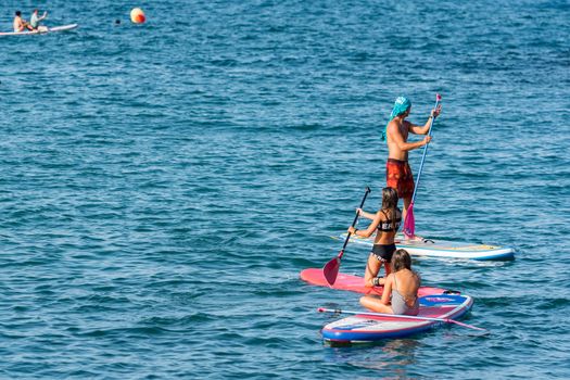 Barcelona, Spain - July 28 2020:  People riding Paddle Surf after COVID 19 La Barceloneta in Barcelona, Spain.